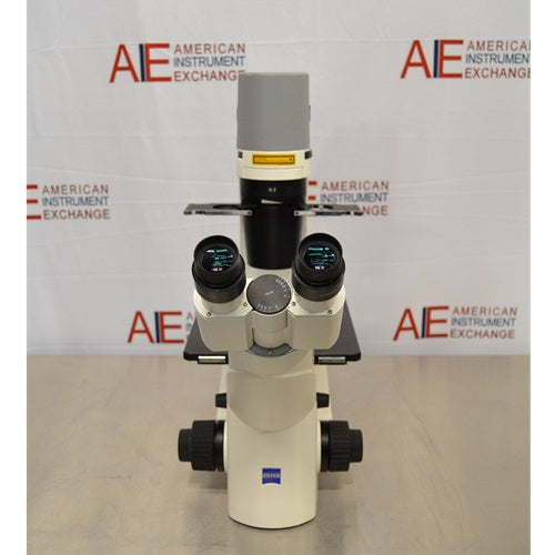 Direct front view of Zeiss Primovert inverted microscope showing dual eyepieces, central Zeiss logo, side focus knobs, and vertical light column