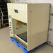 An alternative angled view of a Kewaunee chemical fume hood secured on a blue pallet, showing its side exterior housing, control panel, and service fixture valves along the interior post.