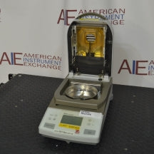 Angled front view of Ohaus MB35 moisture analyzer balance with open heating hood showing interior gold chamber