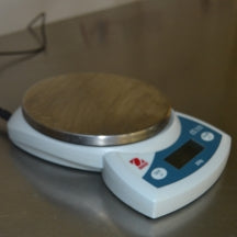 Angled side view of Ohaus CS 200 compact digital scale on metallic surface