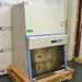 An alternative angled view of a Thermo Scientific 1342 biosafety cabinet on a wooden pallet, showing the stainless steel interior workspace, control console, and side exterior panels.