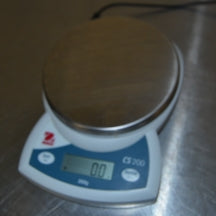 High-angle view of powered-on Ohaus CS 200 compact digital scale displaying zero